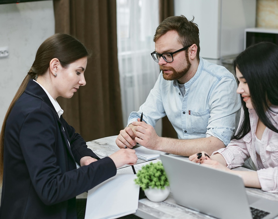 Doradca ubezpieczeniowy omawiający z klientami ofertę ubezpieczenia